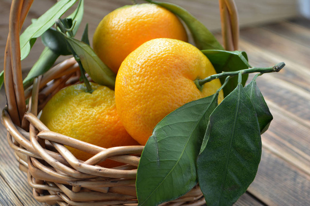 Ripe tangerines with leaves in a basket - Fotografie, Obrázek
