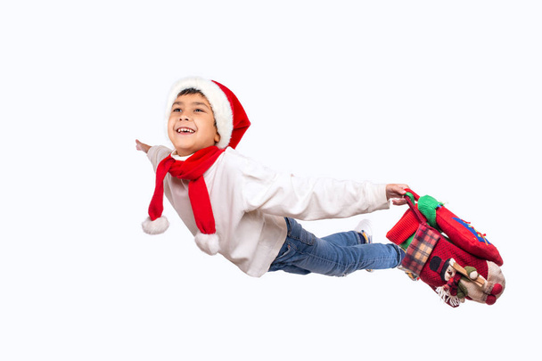 Estúdio tiro de sorrir criança engraçada em Santa chapéu vermelho segurando Chri
 - Foto, Imagem