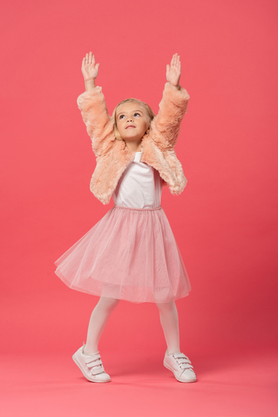 słodkie i stylowe dziecko w z wyciągniętymi rękami na różowym tle  - Zdjęcie, obraz