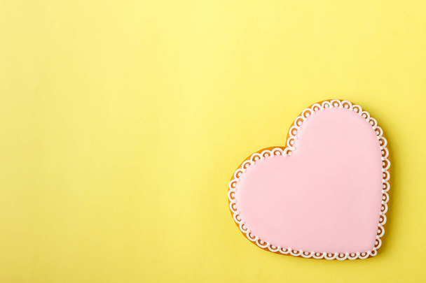 Corazón de galleta rosa con diferentes patrones, fondo amarillo
 - Foto, imagen