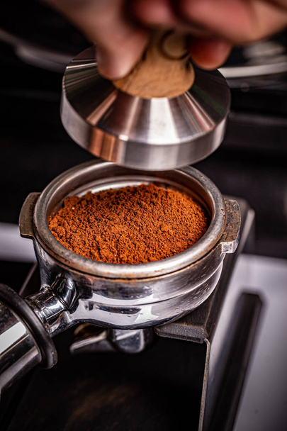 Barista presses ground coffee - Zdjęcie, obraz