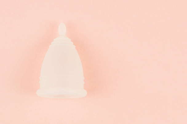 Primer plano de la copa menstrual sobre fondo rosa
 - Foto, Imagen