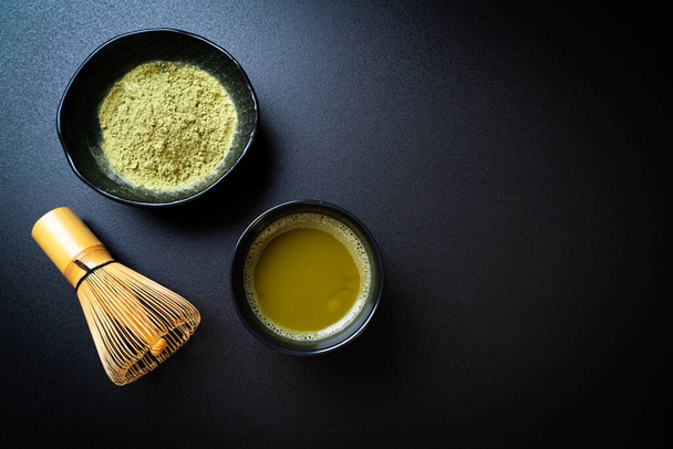 hot matcha green tea cup with green tea powder and whisk - Фото, изображение