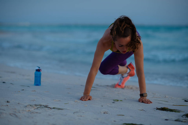 Akşamları okyanus kıyısında spor kıyafeti giyen sağlıklı spor kadını.. - Fotoğraf, Görsel