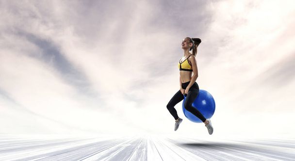 Sporty woman on fitness ball. Mixed media - 写真・画像