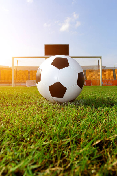 Fußball auf dem Rasen und haben ein orangefarbenes Licht wie die Sonne. - Foto, Bild