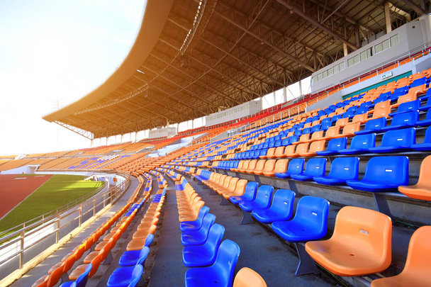 Estadios y asientos vacíos y tienen una luz naranja como el sol
. - Foto, imagen