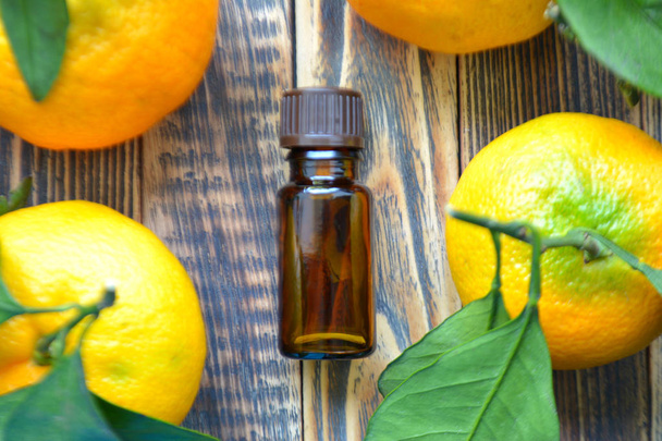 Tangerine cosmetic essential oil in glass bottle. Natural organic cosmetics, aromatherapy and spa concept - Photo, image