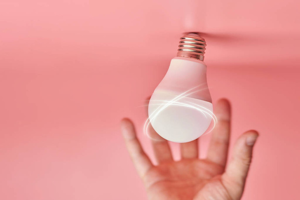Light bulb and hand, idea catching concept. Symbol of new events or finding solutions to problems. Creative minimal innovations. - Photo, Image