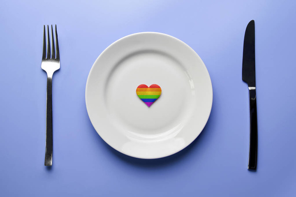 Heart in LGBT flag colors in plate. Romantic gay dating in cafe or restaurant. Waiting for special LGBT guest for wedding banquet. - 写真・画像