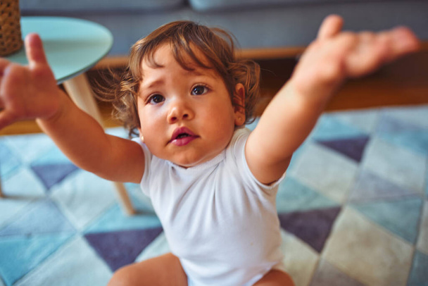 Beautiful toddler child girl wearing white t-shirt playing on the carpet - Foto, Imagen