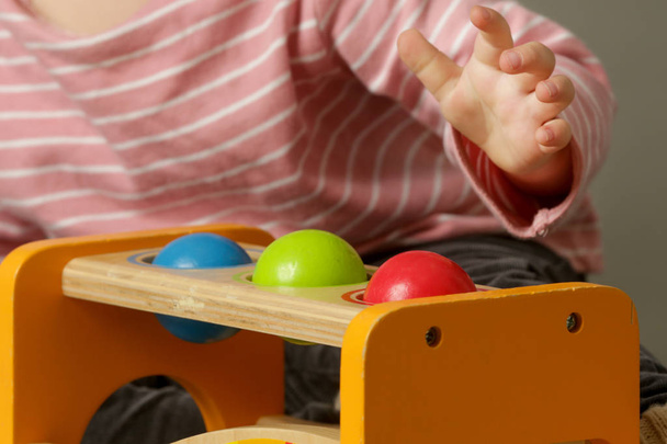 Batole barevné párování míče hra, dítě hrát s barevnými dřevěnými kuličkami, motorové dovednosti koncepce - Fotografie, Obrázek