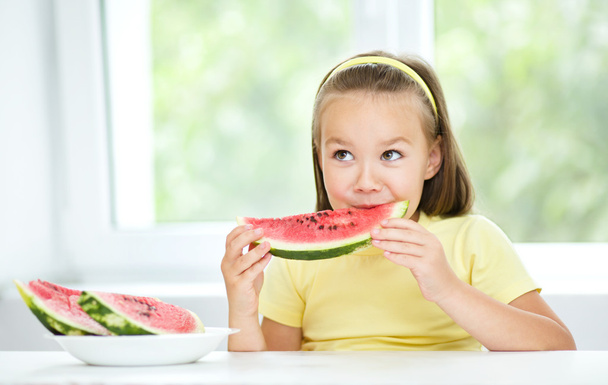 Cute little girl is eating watermelon - Foto, imagen