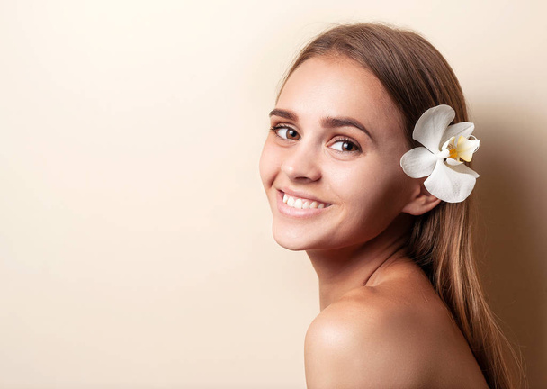 Portret van een lachend blondje op een lichte achtergrond met lege ruimte. Close-up gezicht met schone huid. Gezicht huidverzorging concept. Voorraadfoto. - Foto, afbeelding