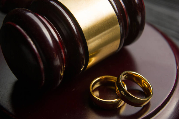 Scheidings- en scheidingsconcept. Twee gouden trouwringen, rechter hamer - Foto, afbeelding