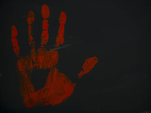 drawing bloody handprint on a black background - Foto, afbeelding