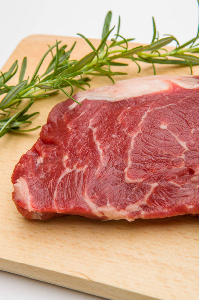 Raw seasoned beef slice on a wooden board - Zdjęcie, obraz