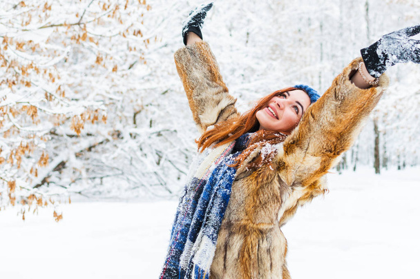 urocza młoda kobieta z podniesionymi rękami raduje się w zimie fo - Zdjęcie, obraz