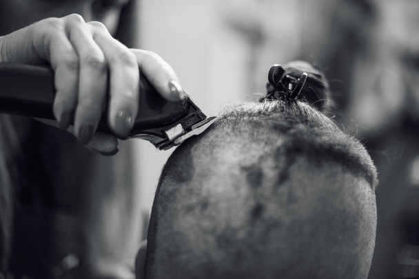 Αρσενικό χίπστερ σε κουρέα κουρείου σε μοδάτο κούρεμα. Ασπρόμαυρη φωτογραφία - Φωτογραφία, εικόνα