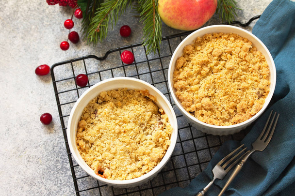 Homemade winter dessert. Apple crumbles with cranberries on a st - Photo, Image