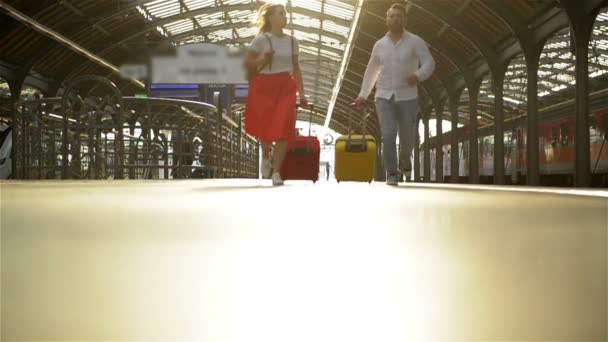 Tren istasyonunda bavulu olan bir çift koşuşturuyor. Tren KalkArken Elinde Pasaport Tutan Kadın. - Video, Çekim