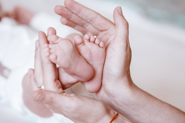 Newborn Baby's feet on female hands closeup. - Zdjęcie, obraz