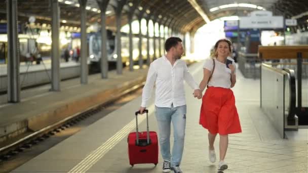 Running Couple With A Suitcase In A Train Station. Woman Holding Passports In Her Hands. - Filmati, video