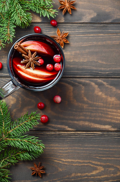 りんごとクランベリーのクリスマス ホットワインします。モミの枝、クランベリー、スパイスで飾られた休日の概念. - 写真・画像