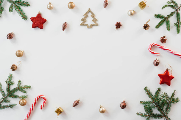 Bright Christmas frame of spruce, brown and gold Christmas decorations, mints on a white background. Copy space. Winter holidays, New year. - 写真・画像