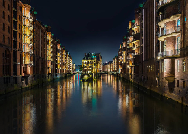 Hamburg 'un Speicherstadt semtindeki eski depo bölgesinde uzun pozlu kanal görüntüsü. - Fotoğraf, Görsel