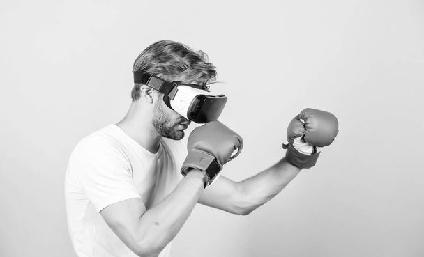 Augmented 3D world. Man boxer virtual reality headset simulation. Man play game in VR glasses. Cyber sport concept. Cyber coach online training. Explore cyber space. Cyber sportsman boxing gloves - Φωτογραφία, εικόνα
