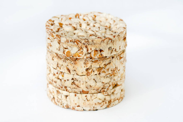 Round crunchy crispbreads on a white background. Round shaped cereal bread, healthy food without yeast. puffed multigrain crispbreads for diet. - Fotoğraf, Görsel