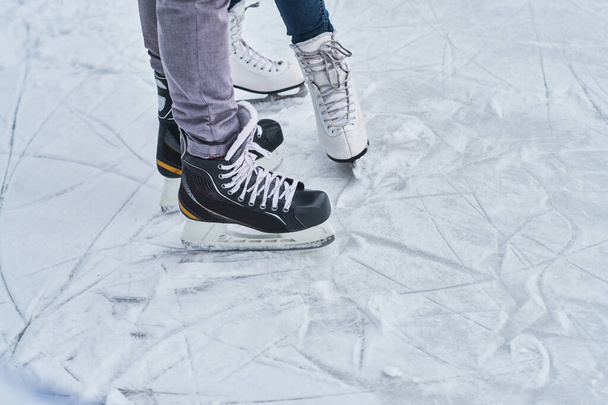 Young loving couple skating at ice rink outdoors - Fotoğraf, Görsel