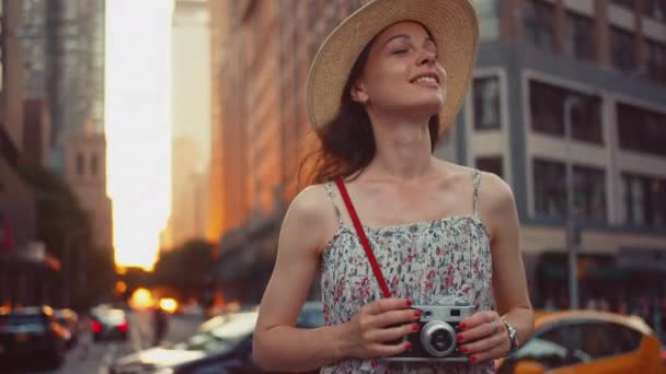 Fiatal fotós retro kamerával New Yorkban naplementekor - Felvétel, videó