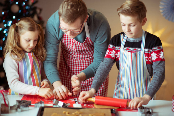 Happy father with his children bakes ginger cookies for Christma - Foto, Bild