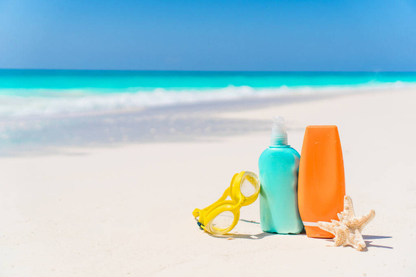 garrafas loção bronzeado do sol e estrela do mar na praia
 - Foto, Imagem