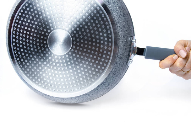 Stylish frying pan in hands on a white background - Foto, afbeelding