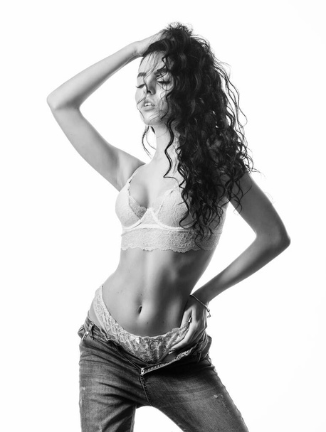 fashion beauty. Diet and fitness.. woman with perfect body relax. sensual girl with curly hair. Flexible body. erotic games. Isolated on white. sexy woman in jeans and bra. In her own style - 写真・画像