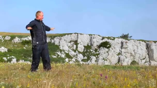 The man is kneaded on a grass in mountains - Footage, Video