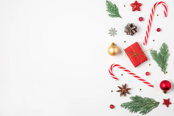Noel kompozisyonu. Firavun ağacı dalları, hediye kutuları, süslemeler, şeker, beyaz arka planda çam kozalakları. en üstteki görünüm - Fotoğraf, Görsel