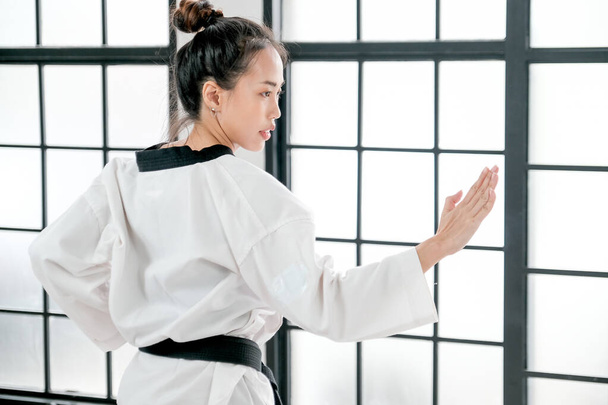 A taekwondo fiatal tanára mutat egy kis testtartást, ami kézzel harcol az ellenkezője felé.. - Fotó, kép