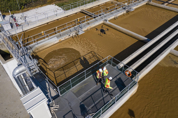 Engineers assesing waste treatment plant with drone - 写真・画像