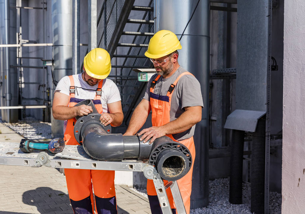 A Pvc csővezetéket összeszerelő munkavállalók - Fotó, kép