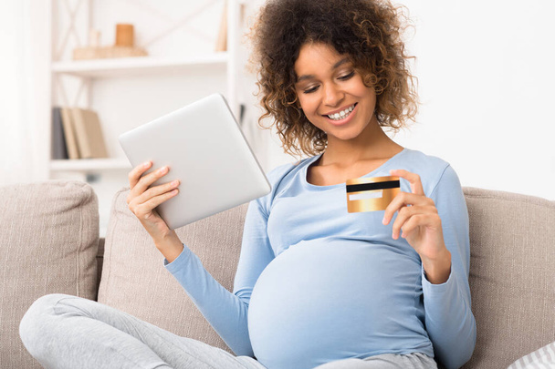 Mujer embarazada haciendo compras en línea y pagando con tarjeta de crédito
 - Foto, imagen