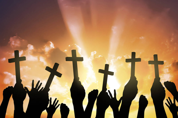 Silueta de personas sosteniendo la cruz cristiana
  - Foto, imagen