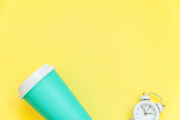 Simplesmente plana leigos projeto azul papel xícara de café e despertador relógio isolado no fundo da moda colorido amarelo
 - Foto, Imagem