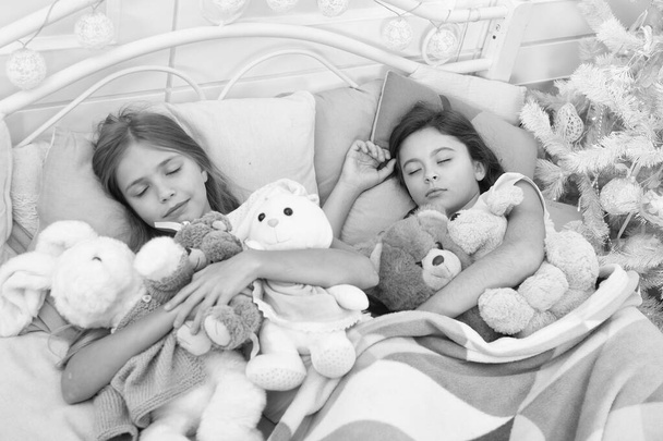 Dreaming in color. Sleeping children. Little children sleep at Christmas tree. Little girls lying in bed with toys. Cute girls fell asleep after Christmas night. Resting on winter holidays - Fotoğraf, Görsel