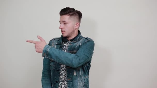 Jovem homem bonito em jaqueta de moda apontando para o espaço para a publicidade
 - Filmagem, Vídeo