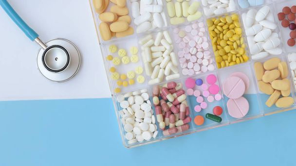 Different medication with stethoscope on white and blue background      - Φωτογραφία, εικόνα