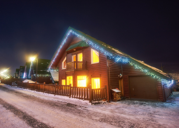 Pequena aldeia nas montanhas nevadas na noite de inverno
 - Foto, Imagem